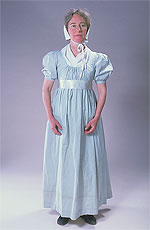 model wearing light blue, empire waist dress and white cotton cap