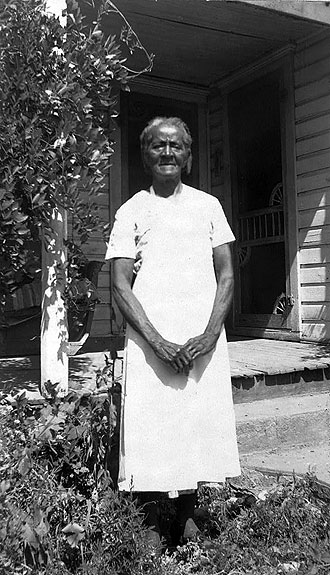file:/activities/oralhistory/cappics/pryor1923_sarah, alt: B/W photo of Sarah Graves in front of porch