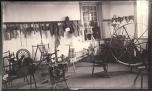 black and white photograph of room full of 19th century spinning equipment