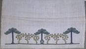embroidered pattern of trees and vines on white linen